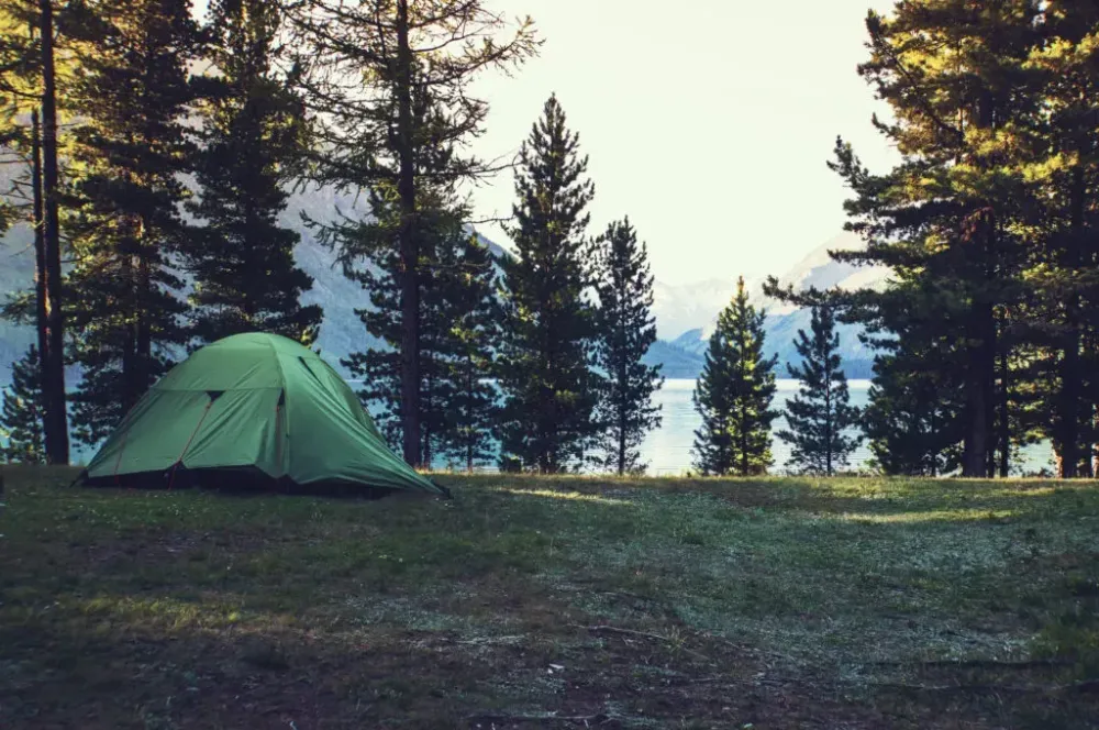 A tent in the woods overlooking a lake